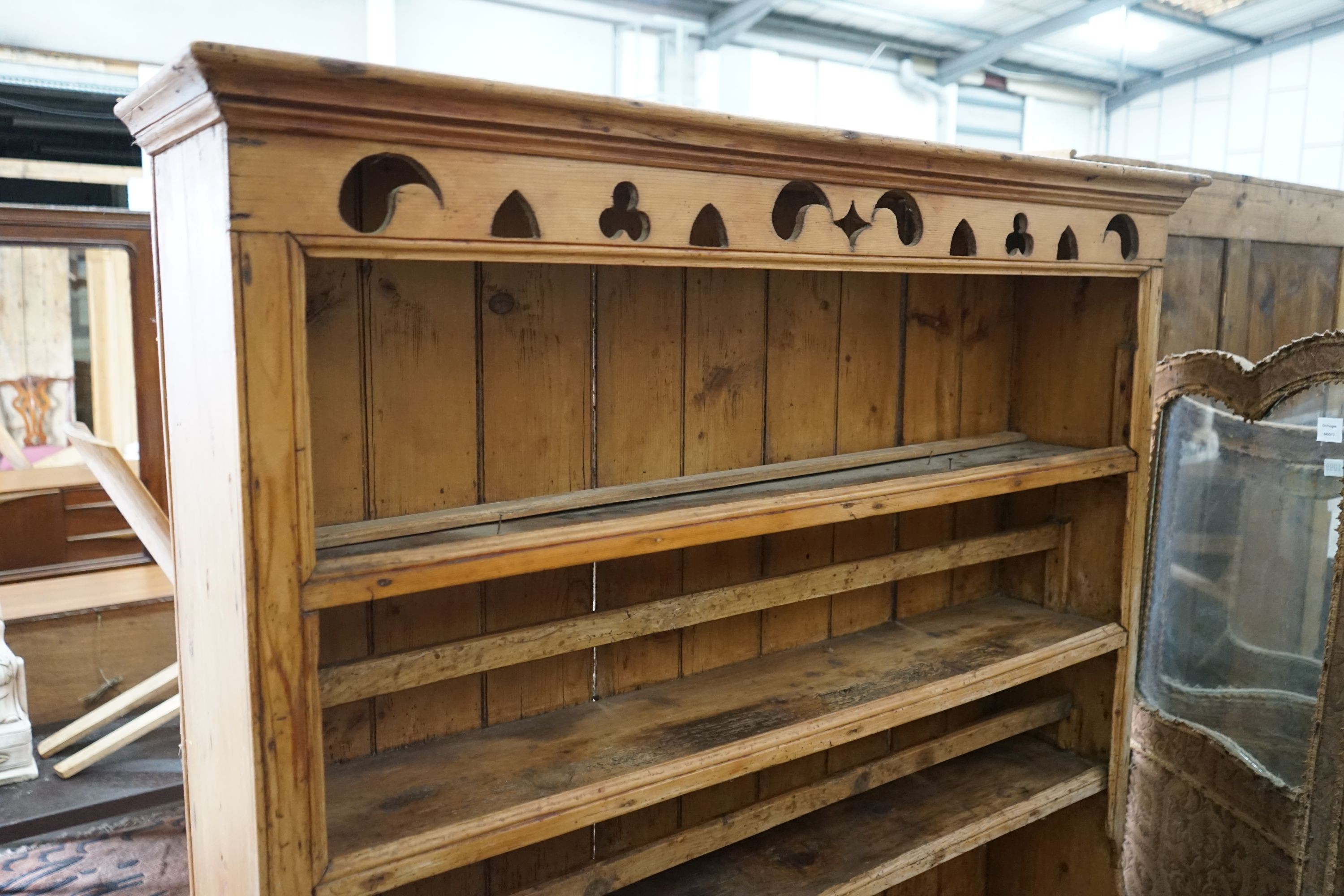 An early 19th century Irish pine dresser with boarded rack, length 129cm, depth 49cm, height 185cm